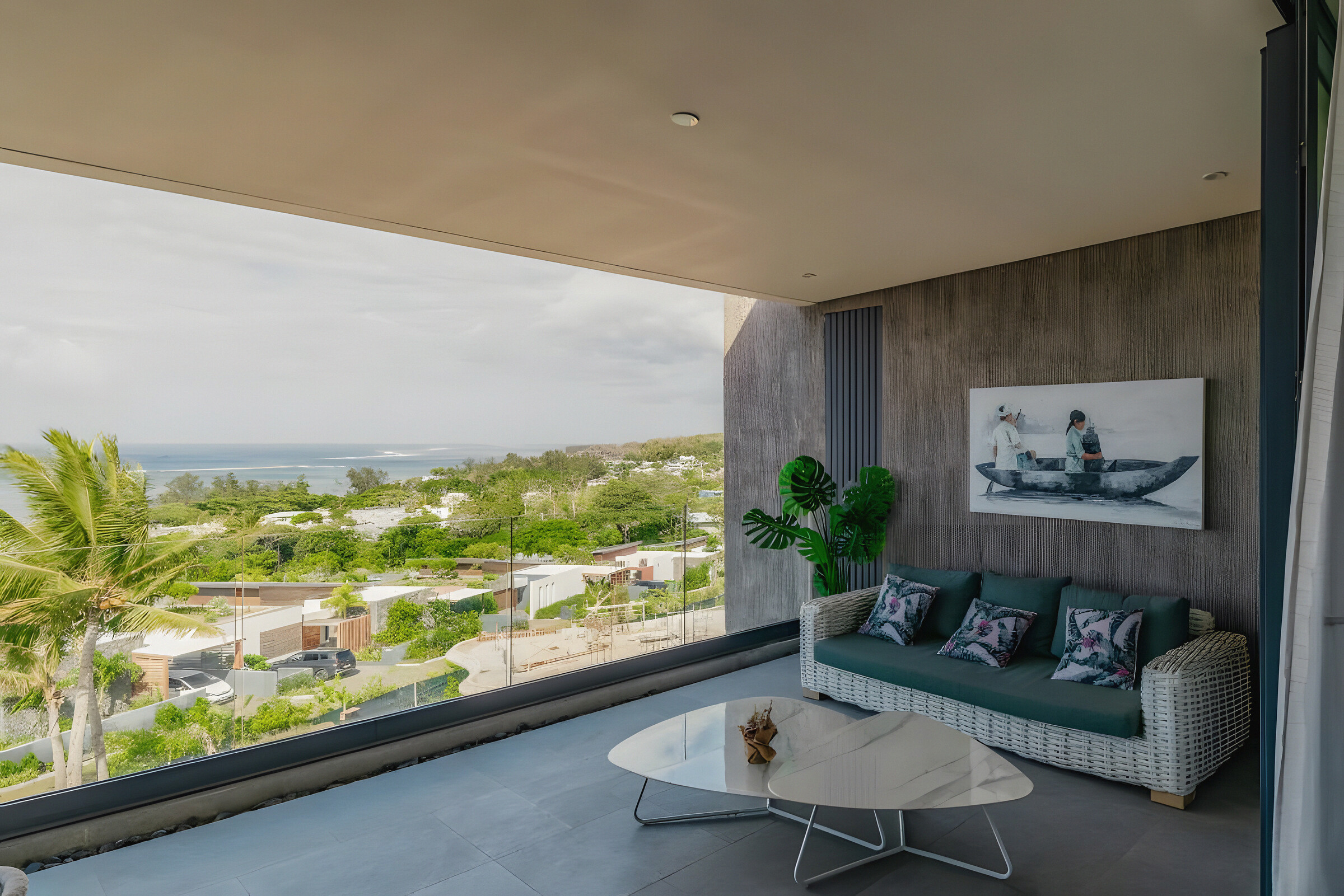 The covered balcony with a sofa and low table, looking out over the coast to the sea